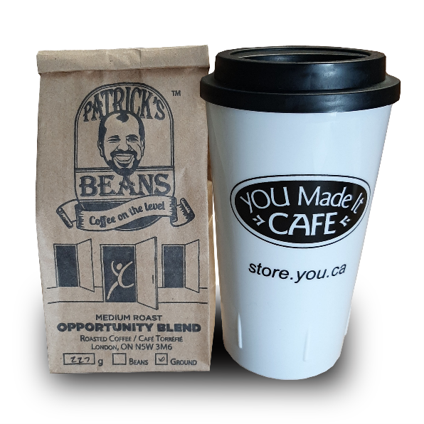 Coffee & Tumbler Combo: the white tumbler features the You Made It Cafe logo and a black lid. The Patrick's Beans are in a customized bag that feature's YOU's signature stick man bursting through a door.