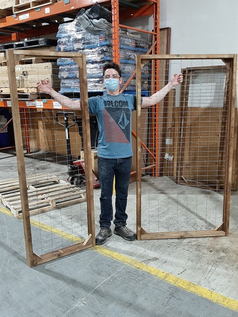 Youth in training holding up two handmade trellises.
